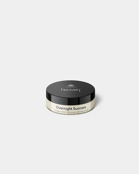 Overnight Success oxygen cream in a clear glass jar with a black lid, featuring botanical organic rose.